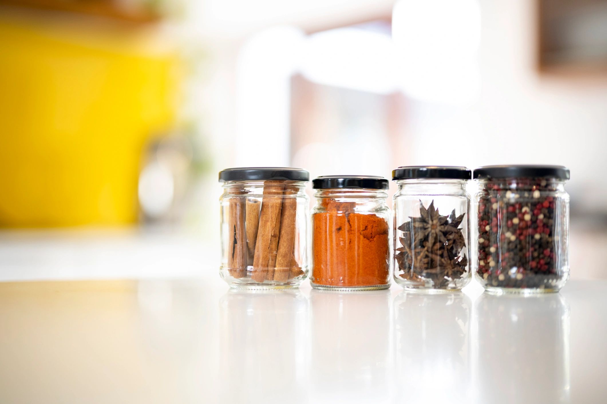 Glass jars filled with spices on a kitchen counter